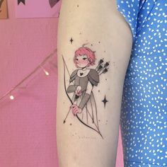 a woman's arm with a small tattoo of a girl on top of an arrow