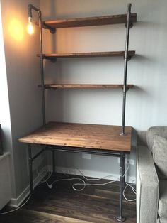 a room with a couch, lamp and shelves on the wall next to a window