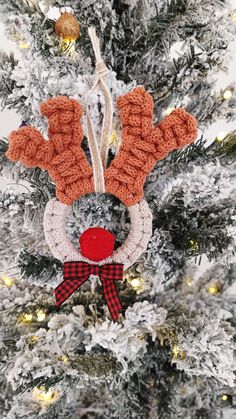 an ornament hanging from the top of a christmas tree with reindeer antlers