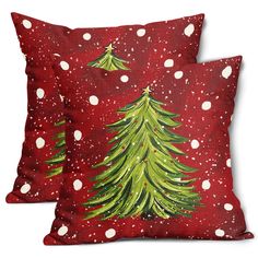 two red pillows with green christmas trees on them