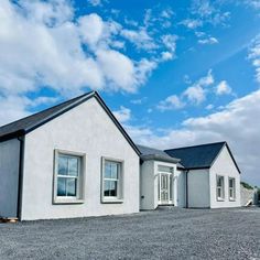 a white house sitting on top of a gravel road