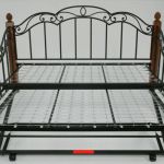 a metal bed frame with wooden posts and headboard