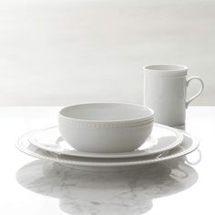 a white plate with two cups and saucers on it next to a cup that is sitting on top of another plate