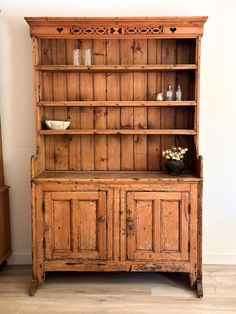 an old wooden bookcase with glass vases on top