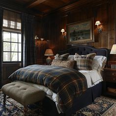 a bedroom with wood paneling and plaid bedding in the corner, along with two lamps on either side of the bed