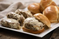 meatball sliders on a white plate with rolls in the background and a napkin