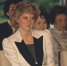 two women sitting next to each other in front of an older woman and another man