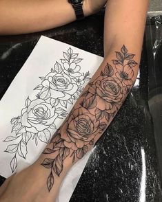 a woman's arm with flowers and leaves on it, next to a drawing