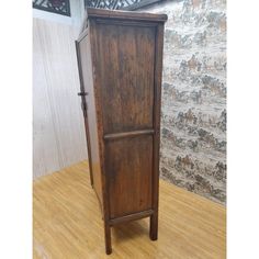 an old wooden cabinet sitting on top of a hard wood floor next to a wall