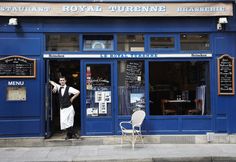 a man standing in the doorway of a restaurant