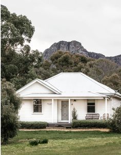 a white house with mountains in the background