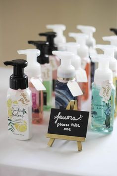 many different types of hand soaps on a table with a sign that says please take one