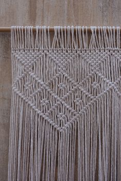 a close up of a piece of cloth on a wooden surface with fringes hanging from it