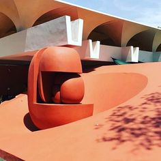 an orange sculpture sitting in front of a building