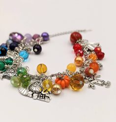 "- Autumn Charm Bracelet Stainless Steel Chain is adjustable from 6.5\" - 9\" with a lobster claw closure and extension chain The bracelet links are filled with a rainbow of glass and gem stone beads and crystals - really pretty. Mixed between the beads and gemstones are autumn themed silver and enamel charms. This is a great gift for anyone who loves the quirky symbols and bright colors of fall. I make these as they are ordered, so the processing time is 4 days. Your bracelet will be carefully Adjustable Multicolor Crystal Bracelet, Adjustable Multicolor Metal Crystal Bracelet, Bohemian Multicolor Metal Charm Bracelet, Bohemian Style Multicolor Metal Charm Bracelet, Adjustable Metal Crystal Bracelet With Charms, Bohemian Multicolor Metal Crystal Bracelet, Nickel-free Multicolor Metal Charm Bracelet, Multicolor Beaded Metal Charm Bracelet, Multicolor Metal Crystal Bracelet Gift