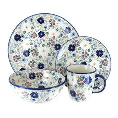 a blue and white dinnerware set with flowers on the front, two cups and one saucer