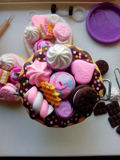 a cupcake decorated with pink, white and chocolate icing on top of a table