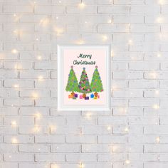 a white brick wall with a christmas card hanging on it's side and lights in the background