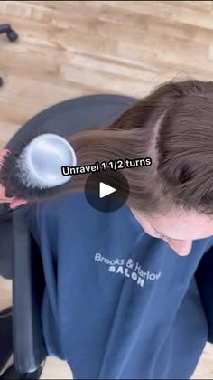 a woman brushing her hair with a brush