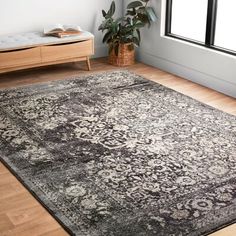 a large area rug with an ornate design on the floor in front of a window