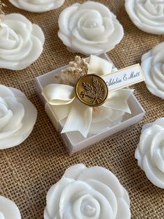 wedding favors with white flowers and gold buttons