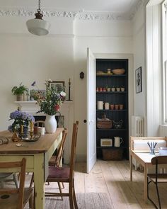 a dining room table and chairs in front of a book shelf filled with pots and pans