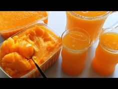 orange juice in plastic containers with spoons next to it and two glasses filled with orange juice