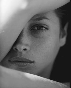 black and white photograph of a woman's face with her hands on her head