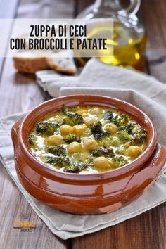 a bowl of broccoli and chickpea soup on a napkin with bread in the background