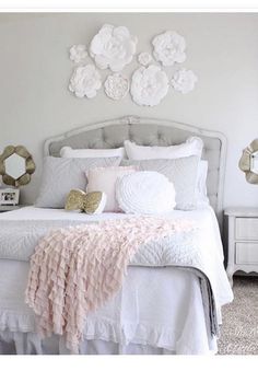 a white bed with pink and gold decor on the headboard is shown in this bedroom