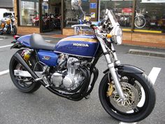 a blue motorcycle parked in front of a store