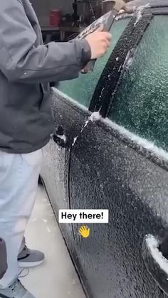 a man is washing the windshield of a car with foam on it and another person standing next to him