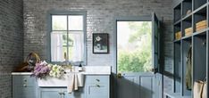 a kitchen with blue cabinets and white counter tops, along with open shelving units