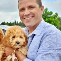 a man holding three dogs in his arms