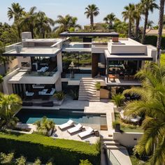 an aerial view of a modern home surrounded by palm trees