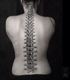 the back of a woman's neck has a skeleton tattoo on it, and there is no image to describe