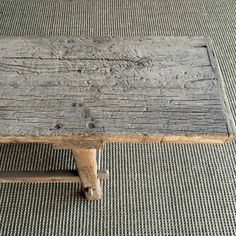 a wooden bench sitting on top of a carpeted floor