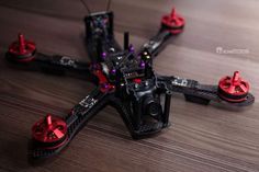 a close up of a remote control helicopter on a wooden table with other parts around it