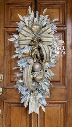 a door with a wreath and ornaments hanging from it's front door, on top of a wooden door