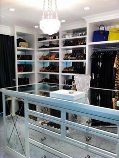 a walk in closet with lots of shoes and handbags on the shelves next to it