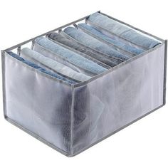 a clear plastic storage box filled with blue jeans on top of a white background,