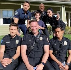 a group of police officers posing in front of a house