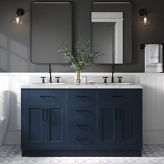 a white toilet sitting next to a blue vanity in a bathroom under two large mirrors