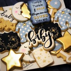 baby cookies are arranged on top of each other with gold and blue decorations around them