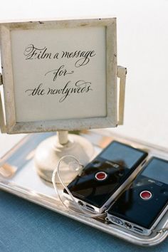 two cell phones sitting on top of a table next to a sign that says turn a message for the newbies