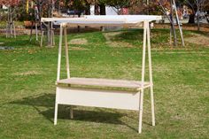 a white bench sitting on top of a grass covered field next to a wooden table