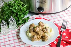 a white plate topped with meatballs covered in gravy next to an instant pressure cooker