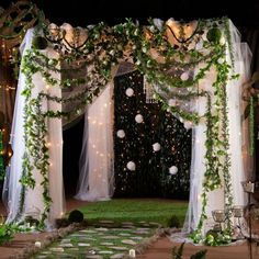 an outdoor wedding venue decorated with greenery and lights