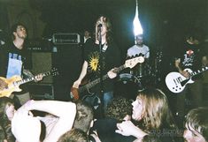 a group of people playing guitars and singing