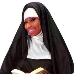 a woman wearing a nun outfit and holding a book